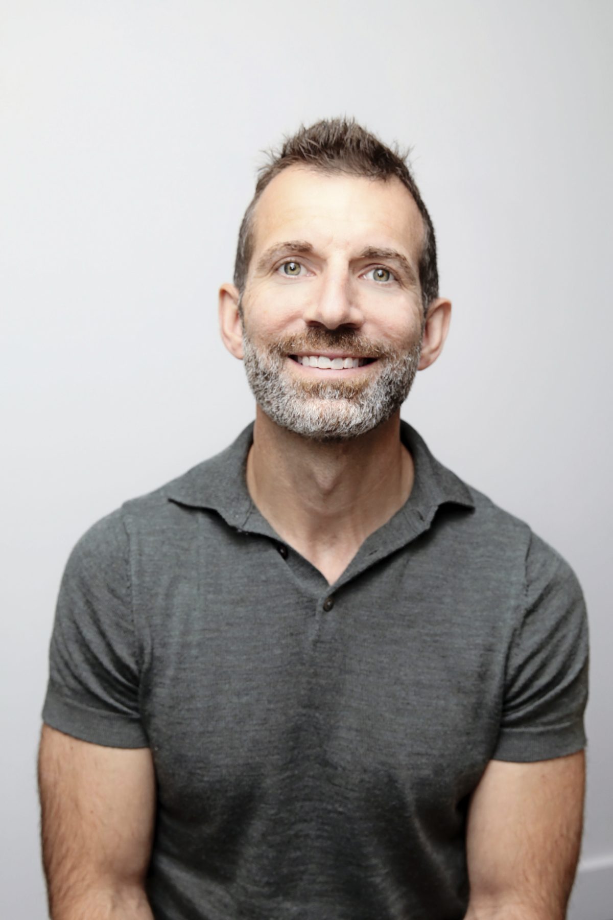 Relaxed professional headshot in a grey polo