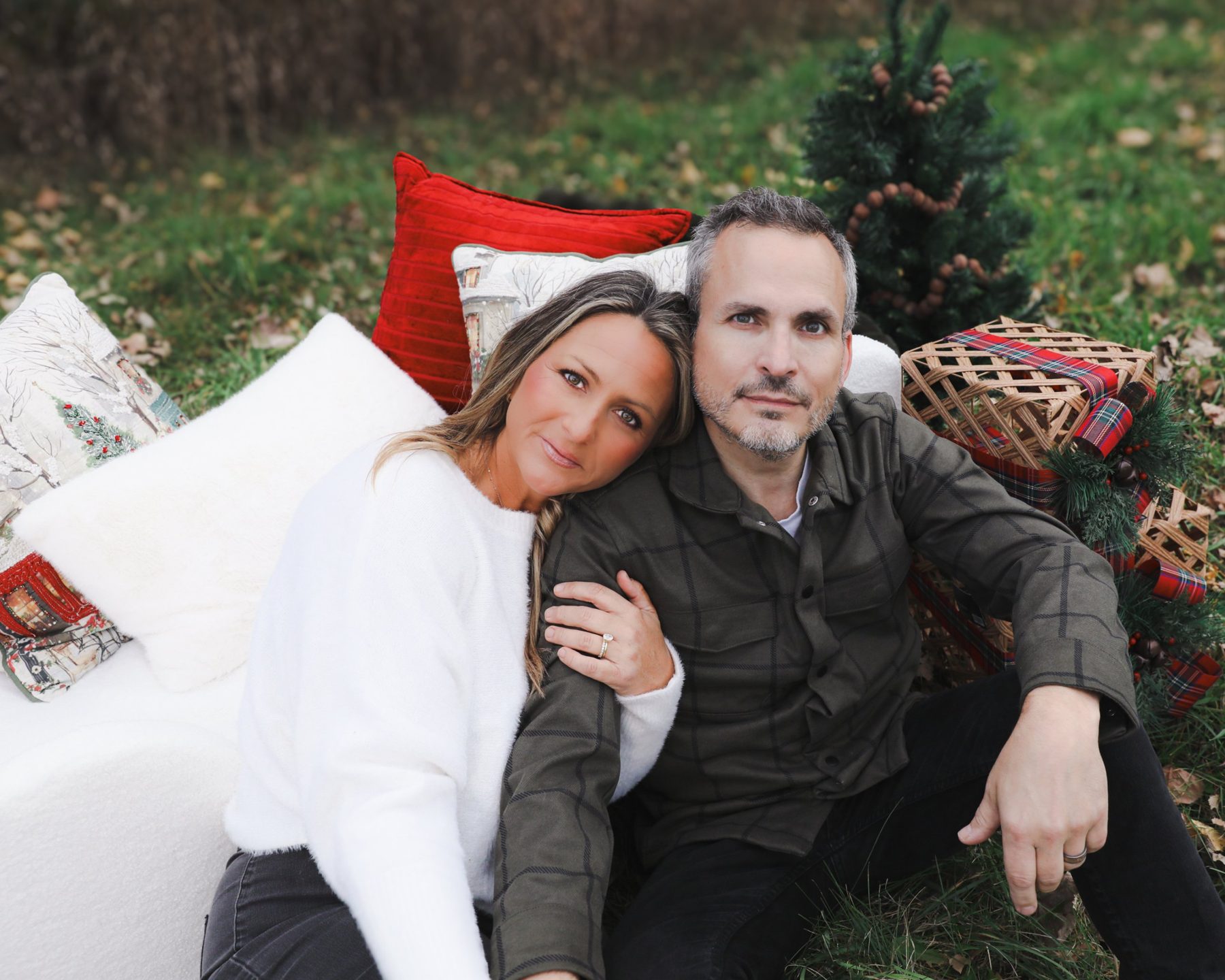 Couple leaning together among holiday pillows