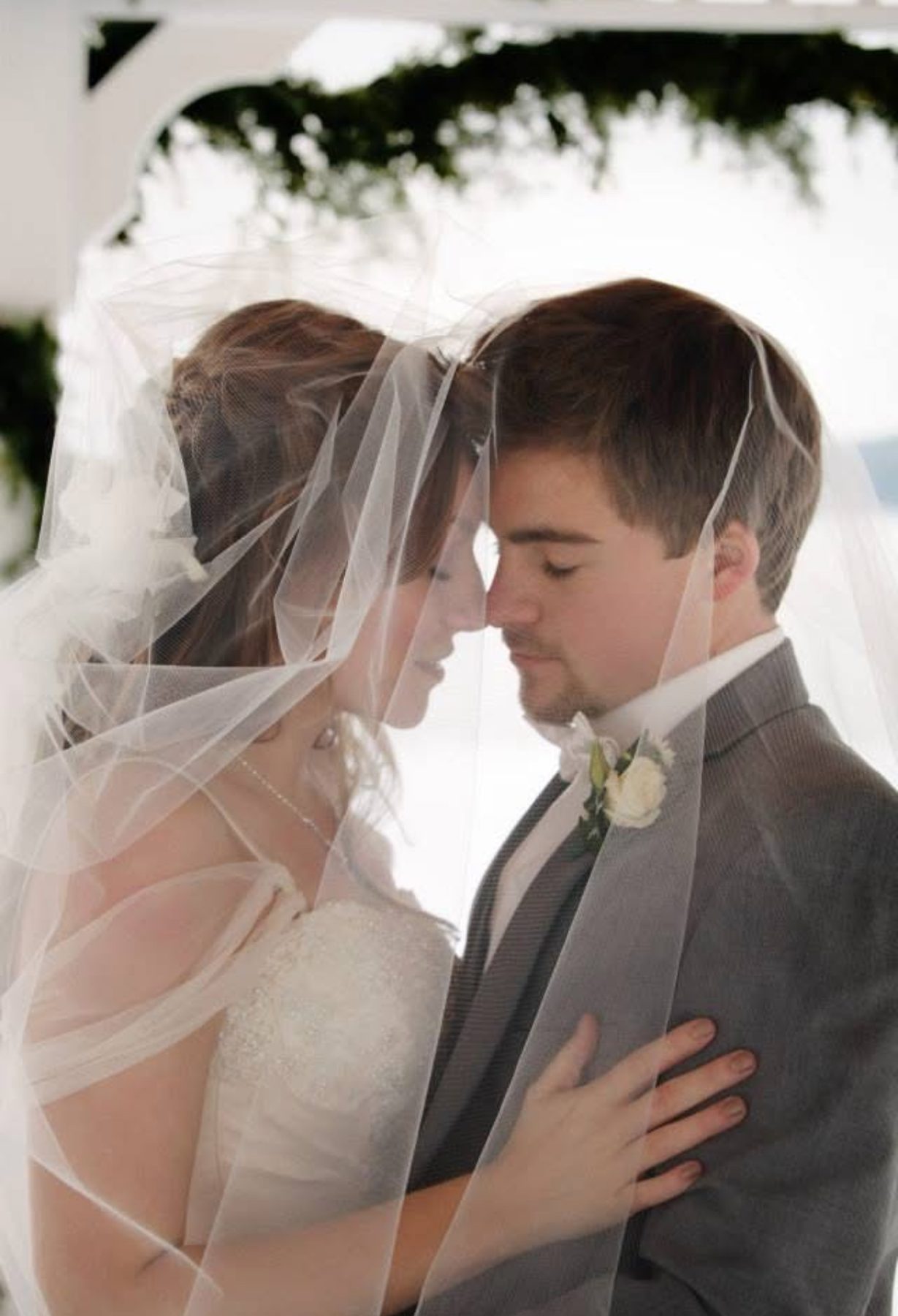 Bride and groom beneath a veil